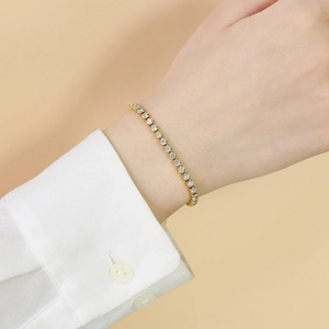 Close-up of a gold-plated tennis bracelet with white round-cut zircon on a wrist