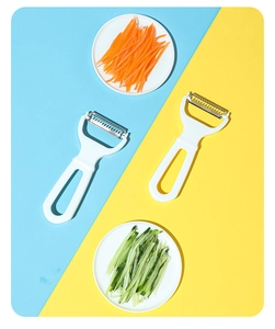 Dual-blade vegetable peeler and grater for carrots and cucumbers on contrast background