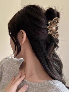 Detailed view of moth shaped hair claw with celestial moon and star patterns on hair