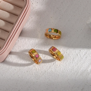 Detail view of 18K gold plated rings with colorful enamel heart, star and smile icons