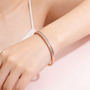 Close-up of rose gold stainless steel bangle with diamond channel setting on wrist