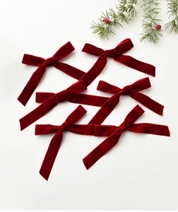 Set of six red velvet Christmas bows with festive pine branch and red berries