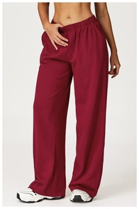 Detail view of burgundy wide-leg joggers featuring an elastic high waist and side pockets