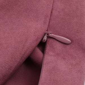 Détail de la fermeture éclair invisible sur tissu suédé vieux rose avec couture