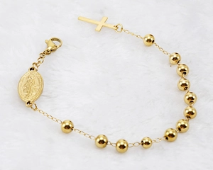 Détail du bracelet religieux perlé plaqué or 18K avec médaille de Marie et croix