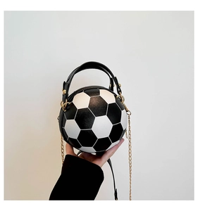 Dettaglio borsa a pallone in pelle bianca e nera con tracolla a catena dorata