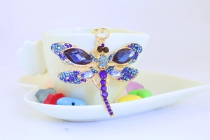 Detailed view of dragonfly keychain with blue crystals and sparkling rhinestones