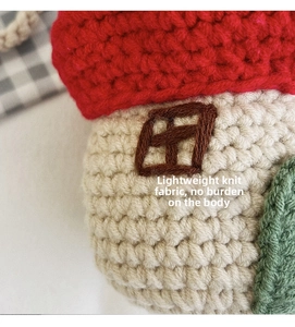 Close-up of handmade crochet house-shaped bag featuring vibrant red roof and knit texture