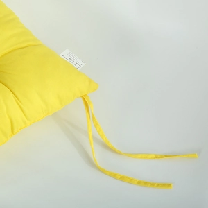 Detail of yellow chair pad with polyester fabric texture and pearl cotton filling specs