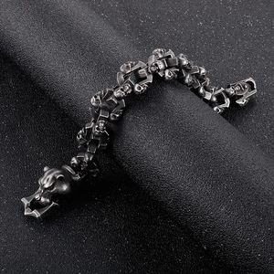 Close-up of gothic leopard head clasp and silver skull links on punk metal bracelet