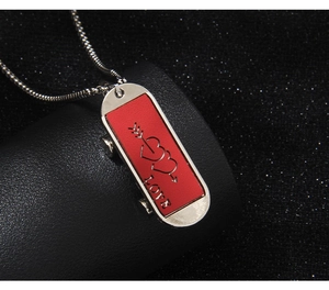 Détail du collier skateboard en argent avec cuir rouge et gravure de cœur romantique