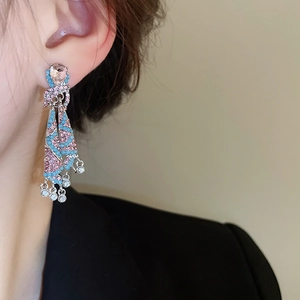 Close-up of bohemian tassel earrings with pink rhinestones and blue turquoise beads