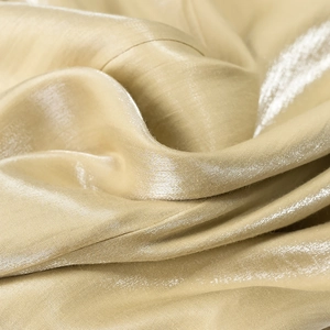 Detailaufnahme der goldenen Satinstruktur mit seidigem Glanz und weichem Faltenwurf