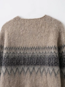Close-up of crew neck knitting and fluffy mohair texture on beige geometric sweater