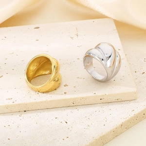18K gold and silver croissant style twisted rings displayed on a stone and satin surface