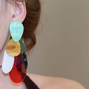 Close-up of model wearing large bohemian style layered multi-color acrylic drop earrings