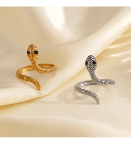 Dettaglio dell'anello a serpente con trama a squame e occhi neri su seta champagne