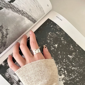Minimalist 925 sterling silver wide ring with irregular hammered texture on model hand