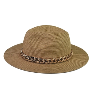 Detail view of straw boater hat featuring a stylish thick gold chain link decoration