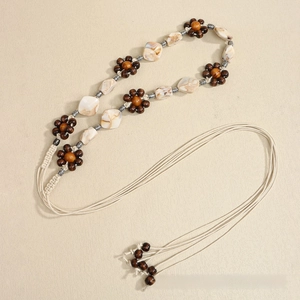 Detail of bohemian braided waist belt with wooden beads and resin marble squares