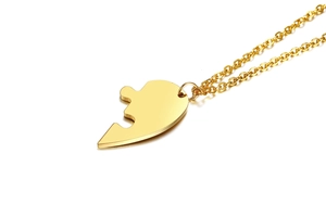Close-up of golden jigsaw puzzle pendant necklace in polished titanium steel