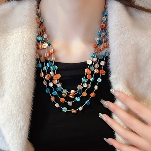 Close-up of multilayer necklace with irregular colorful shell beads on female model