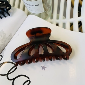 Large tortoiseshell resin hair claw clip with cutout design and amber floral pattern