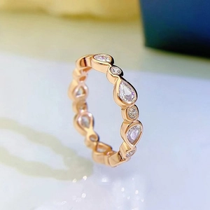 Detalle de anillo en oro rosa con circonitas de talla pera y redonda en engaste bisel