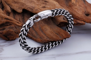 Detailed view of braided stainless steel and leather bracelet with durable pressure clasp