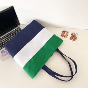 Detailed top view of tri-color canvas tote bag featuring navy white and green panels