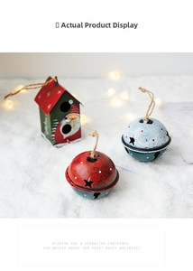 Detail of vintage iron Santa bells and house charms on white snow with warm lights
