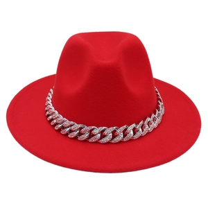 Close-up of a red felt jazz hat featuring a sparkling rhinestone-studded silver chain band