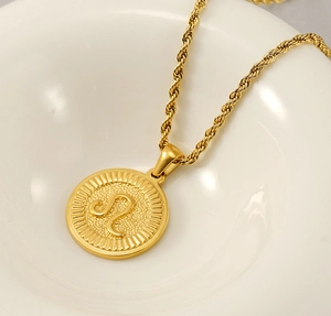 Macro view of 18k gold Leo constellation pendant with embossed lion symbol and rope chain