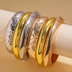 Three-piece geometric metal bangle set in gold, silver, and rose gold finishes