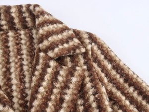 Vue macro du tissu en laine bouclée texturée marron et du col à revers du manteau