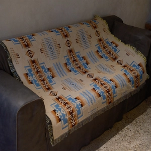 Close-up of Bohemian geometric woven blanket with long tassels and thick cotton texture