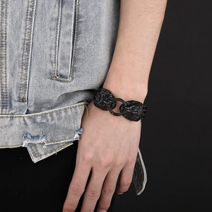 Detail of men's matte black double lion head bracelet worn on wrist for a rugged style