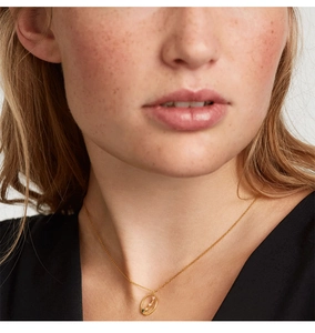 Close-up of gold S925 silver necklace with blue sapphire pendant on a model neck