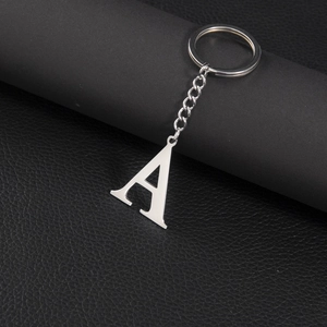Polished silver stainless steel letter A keychain on premium black leather texture