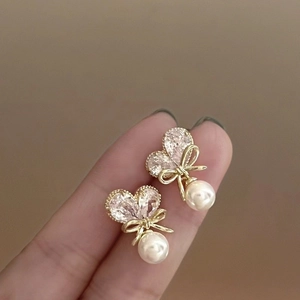 Elegante goldene Herzohrringe mit Zirkon, Schleife und einer hängenden weißen Perle