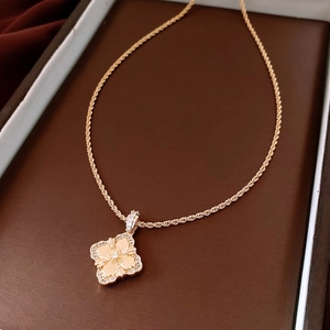 Detail of 18K gold plated flower pendant with rhinestones and textured petals on a chain