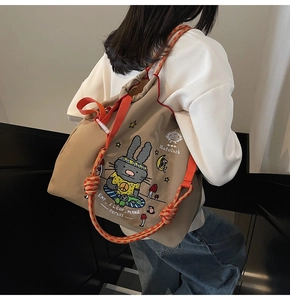Detail view of khaki canvas drawstring backpack with orange ropes and cartoon rabbit print