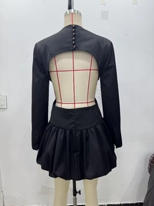 Détail de la mini-robe ballon noire dos nu avec boutons dorés au col arrière