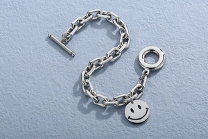 Detailed shot of silver chunky chain bracelet with OT toggle clasp and smiley face charm
