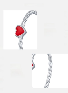 Macro detail of S925 sterling silver twisted band ring with red enamel heart accent