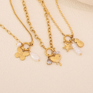 Three gold stainless steel necklaces with pearl and butterfly pendants on beige background