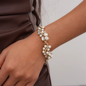 Detail of elegant baroque gold bracelet with white pearls and sparkling crystals on wrist