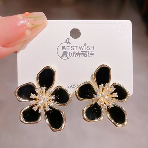 Detailed close-up of S925 silver flower earrings with black petals and gold-rimmed edges