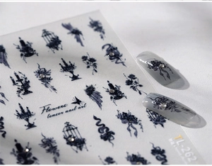 Macro detail of gothic style nail stickers featuring black flowers and vintage birdcages