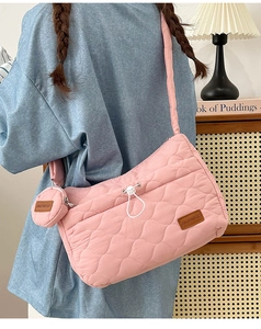 Détail du sac bandoulière rose matelassé avec pochette assortie et étiquette en cuir